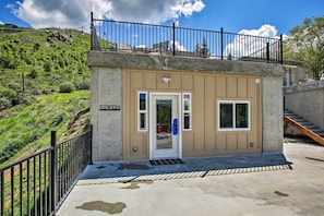 A small, single-story building with a beige exterior and a black metal railing on the upper level. - Lava Hot Springs Studio 4-min Walk to Pools! (Lava Hot Springs)