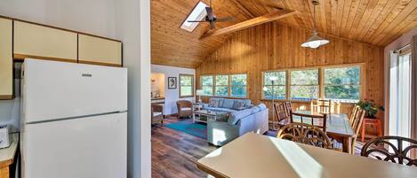 A spacious living area with a wooden ceiling, a large window, and a sofa.