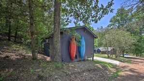 Una pequeña cabaña de madera con dos kayaks amarrados a un lado.