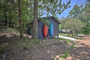 A small wooden cabin with two kayaks mounted on its side.