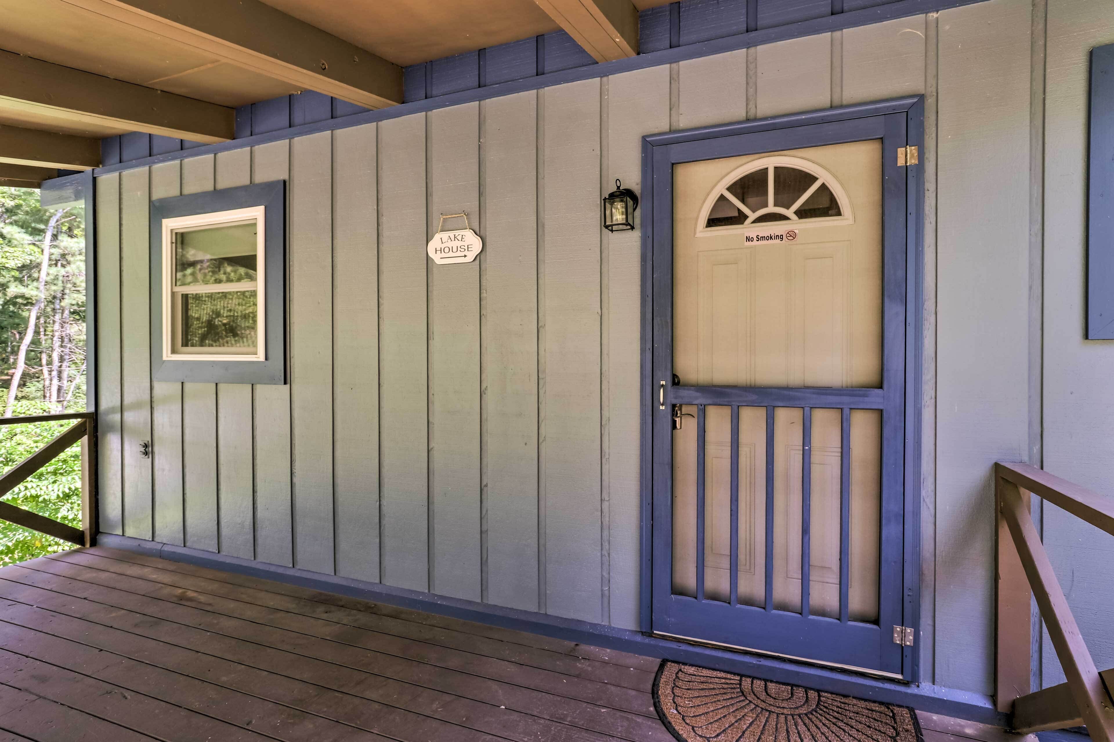Ein Holzhaus mit blauer Tür, einem kleinen Fenster und einem Rauchverbot-Schild.