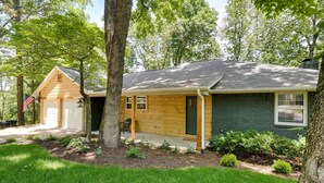 A two-story house with a garage, a front porch, and a well-maintained lawn.