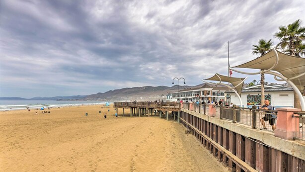 A beach with a wooden boardwalk, a pier, and a building with a beach view. - Pismo Beach Condo < Walk to Beach & Wineries! (Pismo Beach)