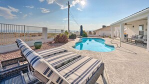 A backyard with a swimming pool, lounge chairs, and a covered patio area. - Pool, Patio & Lake Views: Lake Havasu City Home! (Lake Havasu City)