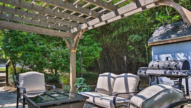 An outdoor patio with wicker furniture, a glass-top table, and a barbecue grill. - Blue Ridge Mountains Cottage w/ Pergola & Fire Pit (Hendersonville)