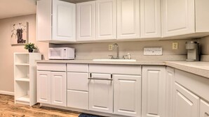 A modern kitchen with white cabinetry, a microwave, a coffee maker, and a small plant on the counter. - Bel Air Apartment w/ Pool ~ 2 Mi to Main St (Bel Air)