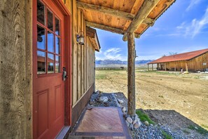 A rustic wooden building with a red door and a covered porch. - Remote Escape: Clark Home w/ Incredible View (Powell)