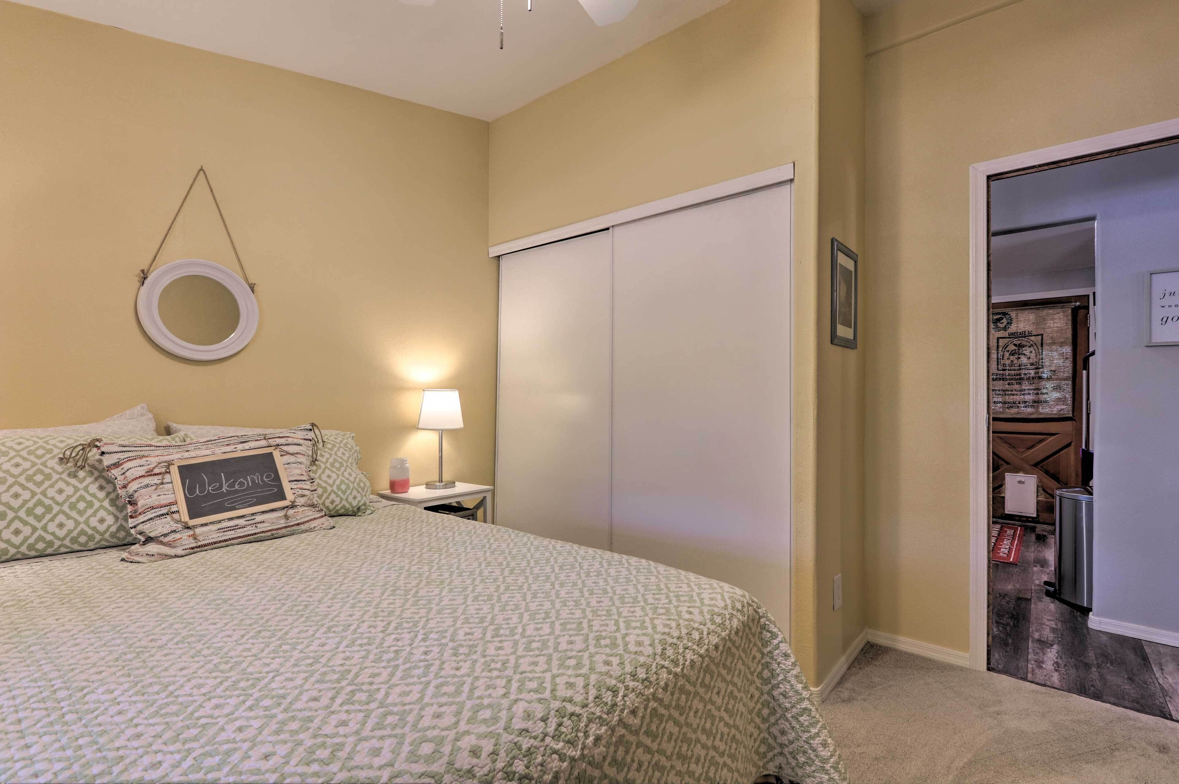 A bedroom with a bed, a bedside table with a lamp, a wardrobe, and a welcome sign.