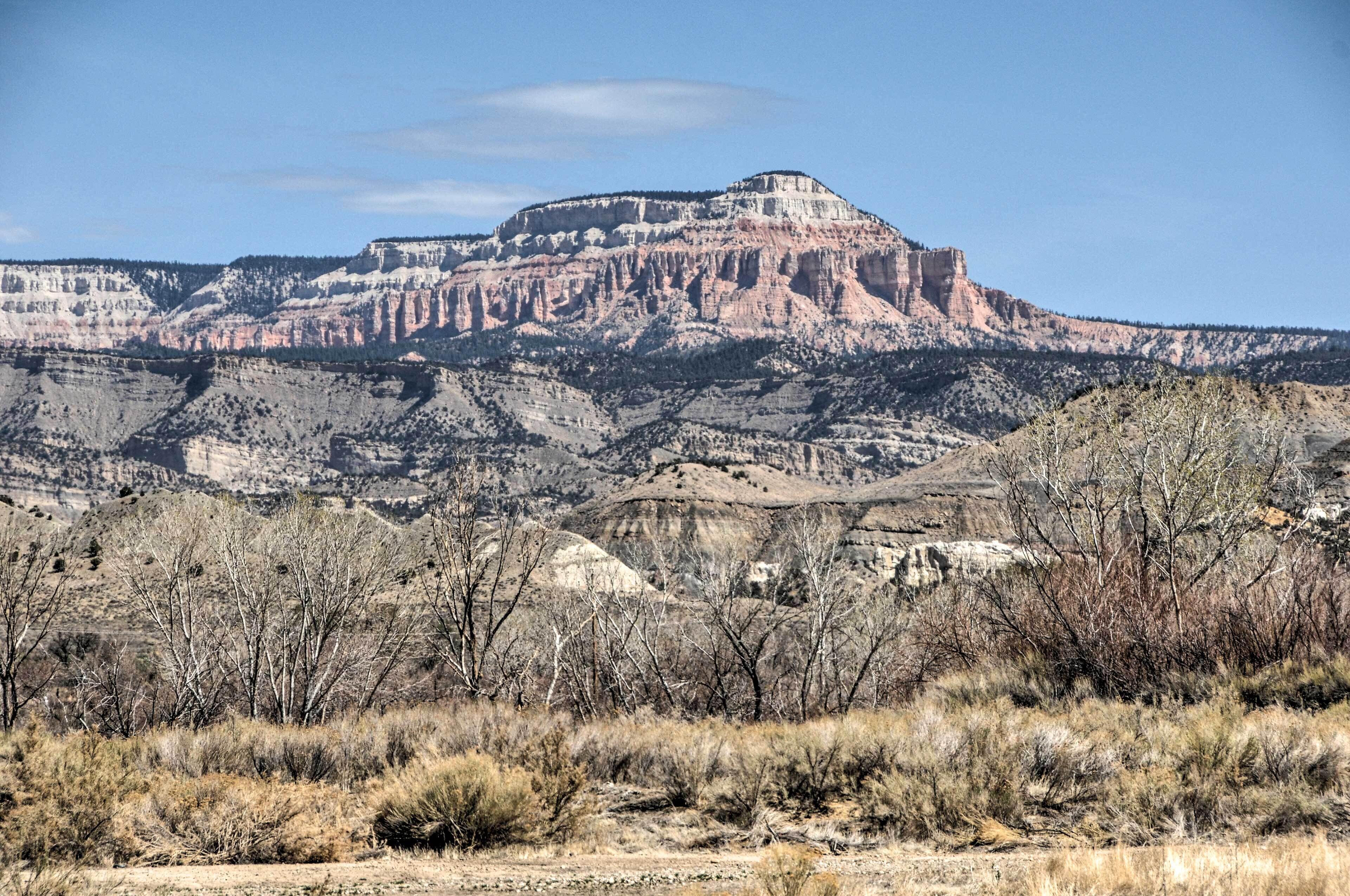 A mountainous landscape with a prominent hill and sparse vegetation.