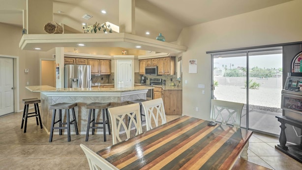 A spacious kitchen with a central island, wooden cabinets, and a large window offering a view of the outdoors. - 2 Mi to London Bridge: Lake Havasu Getaway (Lake Havasu City)