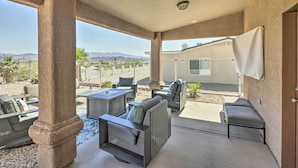 A covered patio area with outdoor furniture, a view of mountains, and a building in the background. - 2 Mi to London Bridge: Lake Havasu Getaway (Lake Havasu City)