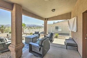 A covered patio area with outdoor furniture, a view of mountains, and a building in the background. - 2 Mi to London Bridge: Lake Havasu Getaway (Lake Havasu City)