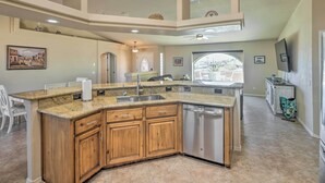 A spacious kitchen with a large island, wooden cabinets, stainless steel appliances, and a view to the outside. - 2 Mi to London Bridge: Lake Havasu Getaway (Lake Havasu City)
