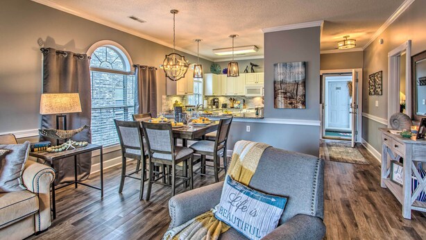A modern living room with a dining area, wooden flooring, and a view of the kitchen. - Myrtlewood Golf Resort Condo With Pool Access (Myrtle Beach)