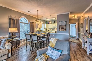 A modern living room with a dining area, wooden flooring, and a view of the kitchen. - Myrtlewood Golf Resort Condo With Pool Access (Myrtle Beach)