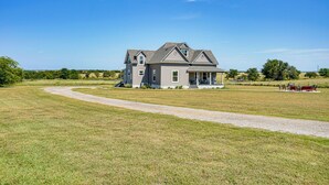 A large house with a porch and a driveway leading to it. - Decatur Farmhouse Getaway w/ Deck & Backyard (Decatur)