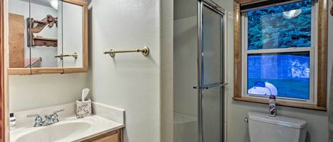 A bathroom with a vanity, sink, mirror, and a window with a view of a boat.