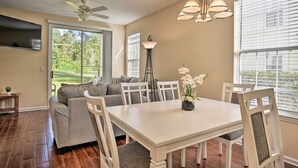 A dining area with a white table and chairs, a ceiling fan, and a floor lamp. - First-floor Myrtle Beach Condo w/ Pool Access! (Myrtle Beach)