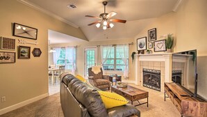 A living room with a fireplace, leather sofa, and a television. - Bella Vista Home: Steps to Mountain Biking Trails! (Bella Vista)