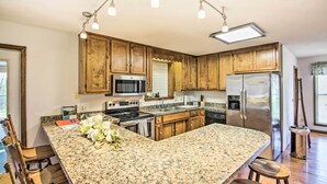 A kitchen with granite countertops, wooden cabinets, stainless steel appliances, and pendant lighting. - Country Home w/ Fire Pit: 40 Mi to Nashville! (Watertown)