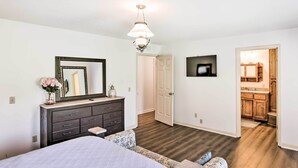 A bedroom with a large bed, dresser, mirror, and a TV mounted on the wall. - Country Home w/ Fire Pit: 40 Mi to Nashville! (Watertown)