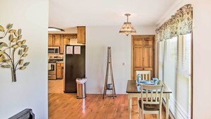 A kitchen with wooden cabinets, a refrigerator, and a dining area with a table and chairs. - Country Home w/ Fire Pit: 40 Mi to Nashville! (Watertown)