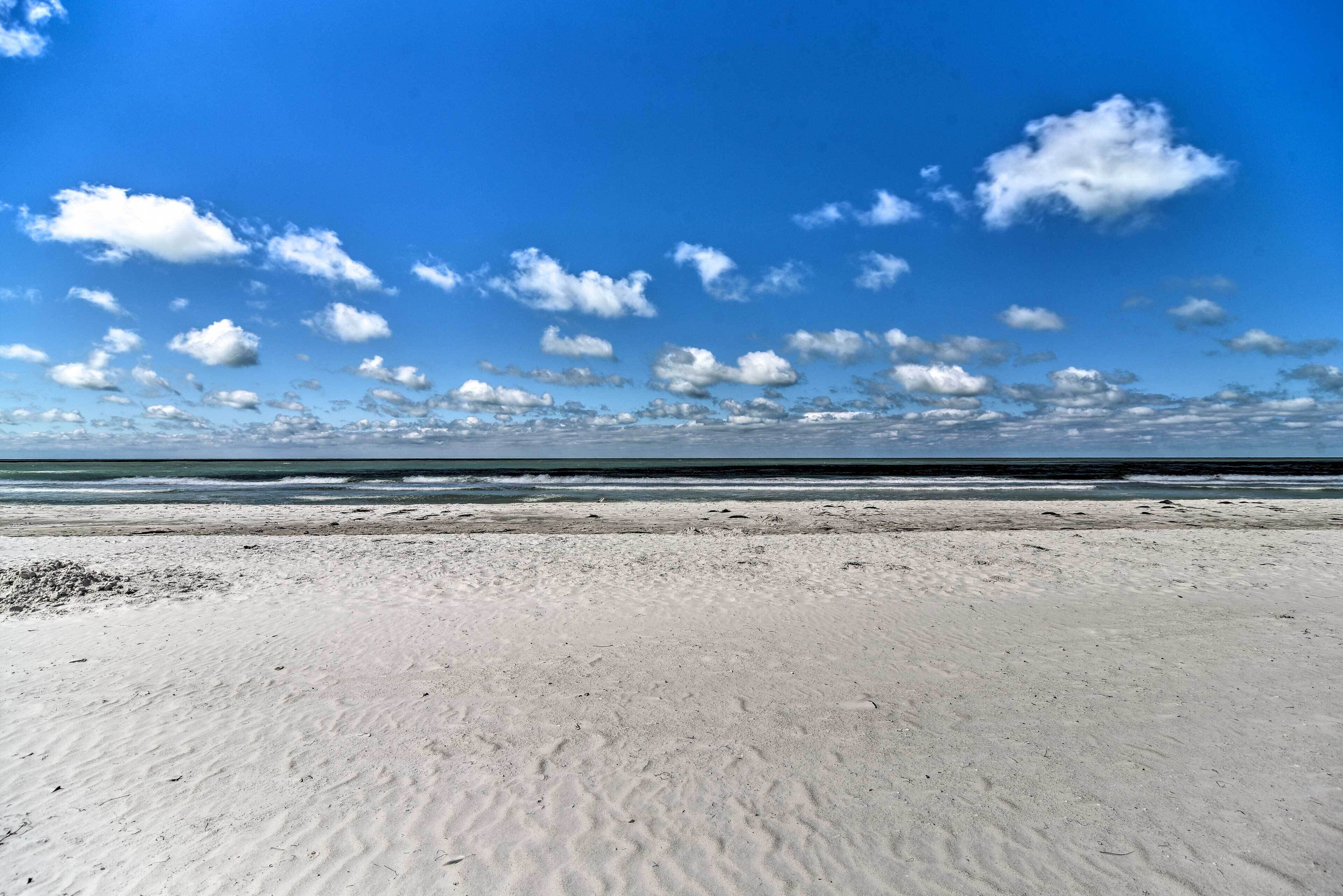 Ein Strand mit blauem Himmel und Meer im Hintergrund.