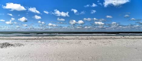 Ein Strand mit blauem Himmel und Meer im Hintergrund.
