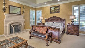 A bedroom with a large bed, a fireplace, and a ceiling fan. - Families Welcome! Lavish Celina Home w/ Game Room (Celina)