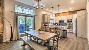A spacious kitchen with wooden cabinets, a dining table with benches, and a large window providing natural light. - 6 Mi to Homewood Mountain Resort: Tahoe City Gem! (Tahoe City)