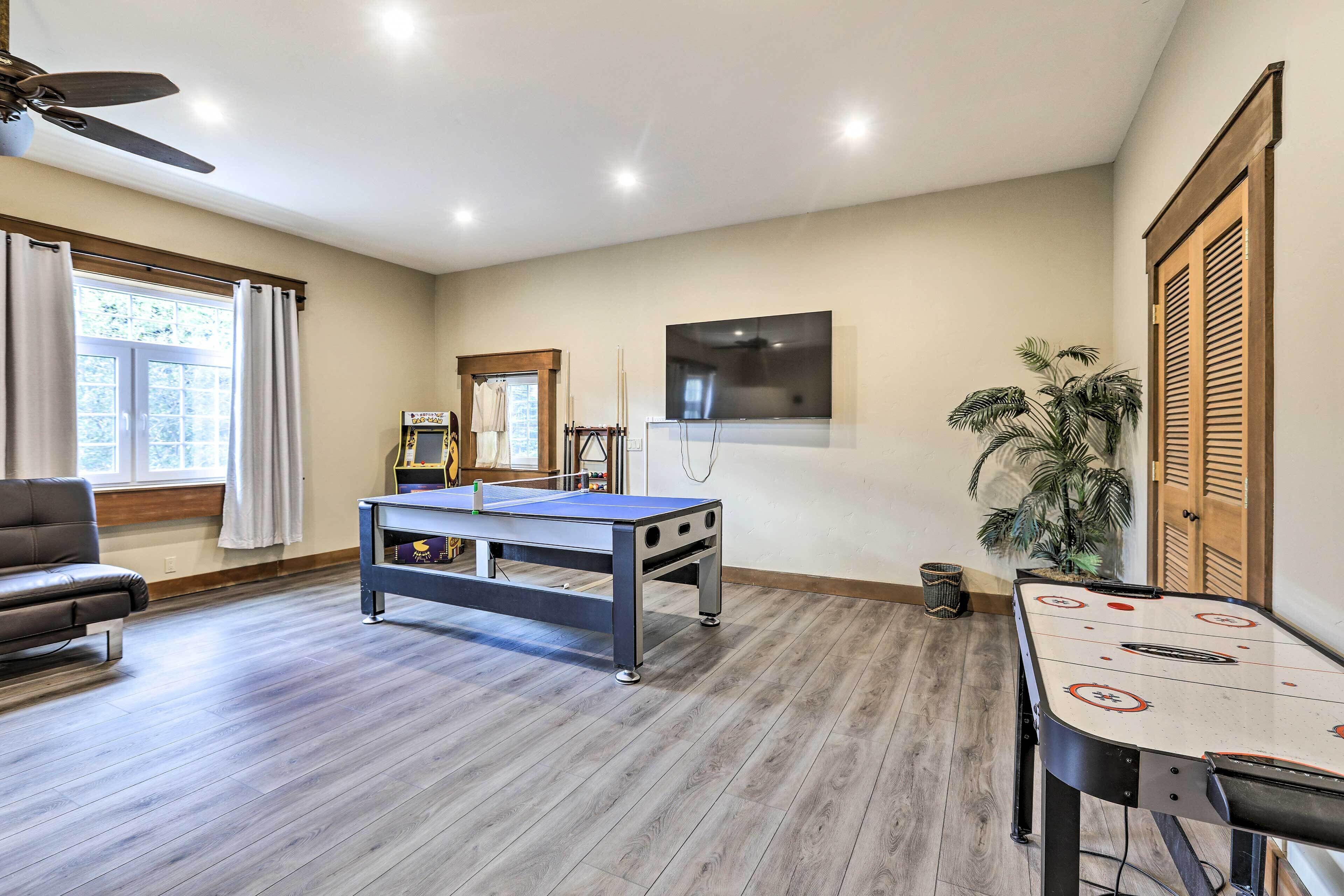 Une pièce spacieuse équipée d’un baby-foot, d’une table de billard et d’un coin salon confortable.