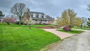 A large house with a driveway and a well-maintained lawn. - Pet-friendly Home 7 Miles to Dickson Street! (Fayetteville)