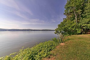 A calm lake with a grassy shoreline and trees.
