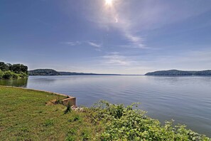 A calm lake with grassy banks and a wooden structure.