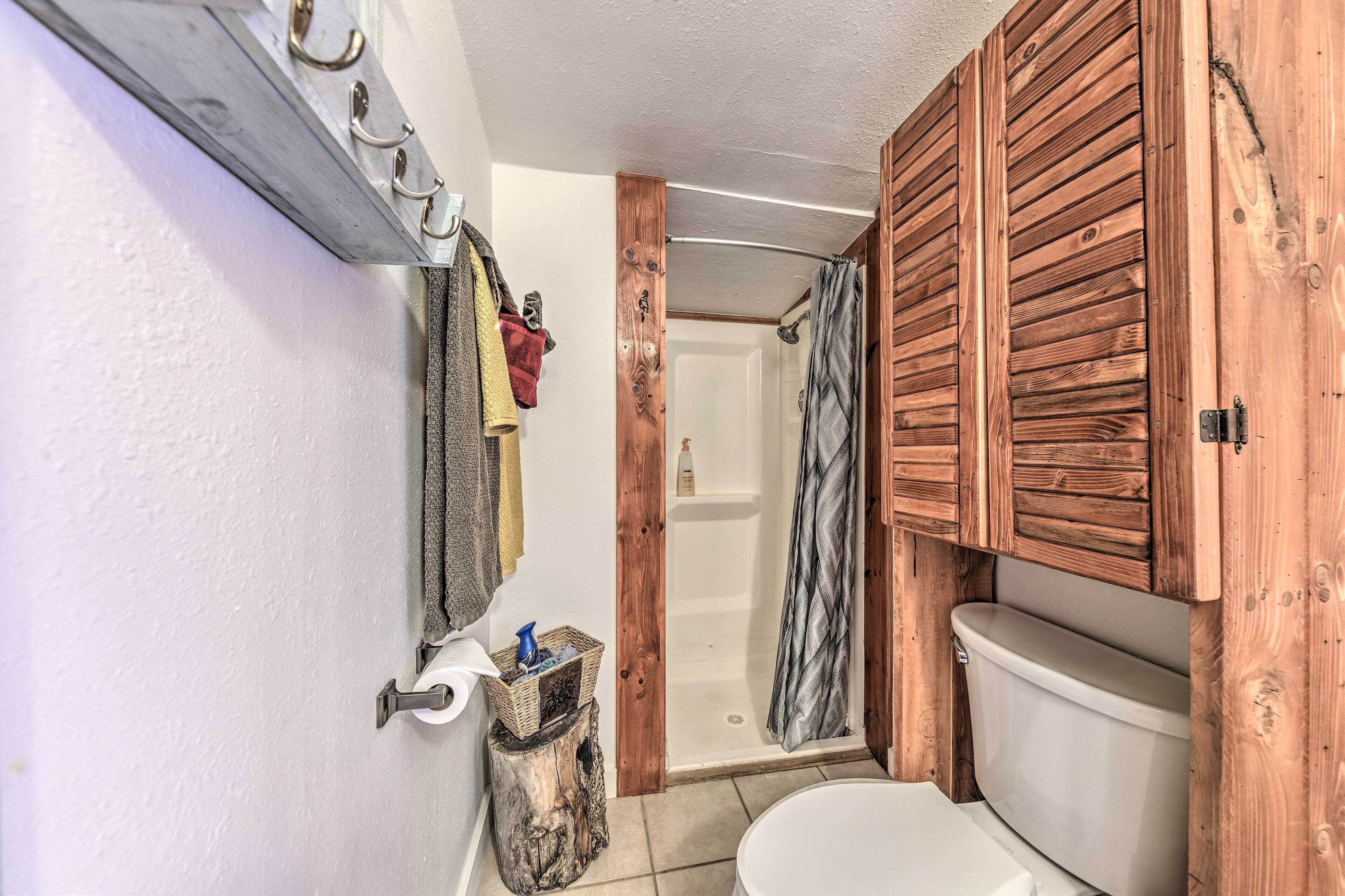 Une salle de bain avec un meuble-lavabo en bois, une douche et des toilettes.
