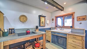 A kitchen with wooden cabinets, a sink, and a window.