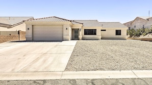 A residential house with a garage, driveway, and gravel lawn. - Fort Mohave Home < 8 Mi to Colorado River! (Fort Mohave)
