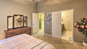 A bedroom with a bed, dresser, and mirrors. There is a ceiling fan, a door leading to another room, and a potted plant. - Fort Mohave Home < 8 Mi to Colorado River! (Fort Mohave)