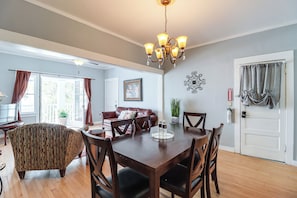 A dining area with a wooden table and chairs, a chandelier, and a view of the outdoors through a glass door. - 'St Blaise' Bisbee Apt < 1 Mi to Attractions! (Bisbee)