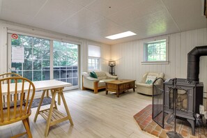 Un salon chaleureux avec une table en bois, un canapé, une table basse et une cheminée.