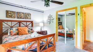 A bedroom with a wooden bed frame, a nightstand, a lamp, and a mirror.