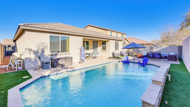Un jardin avec une piscine, du mobilier de jardin et une maison.