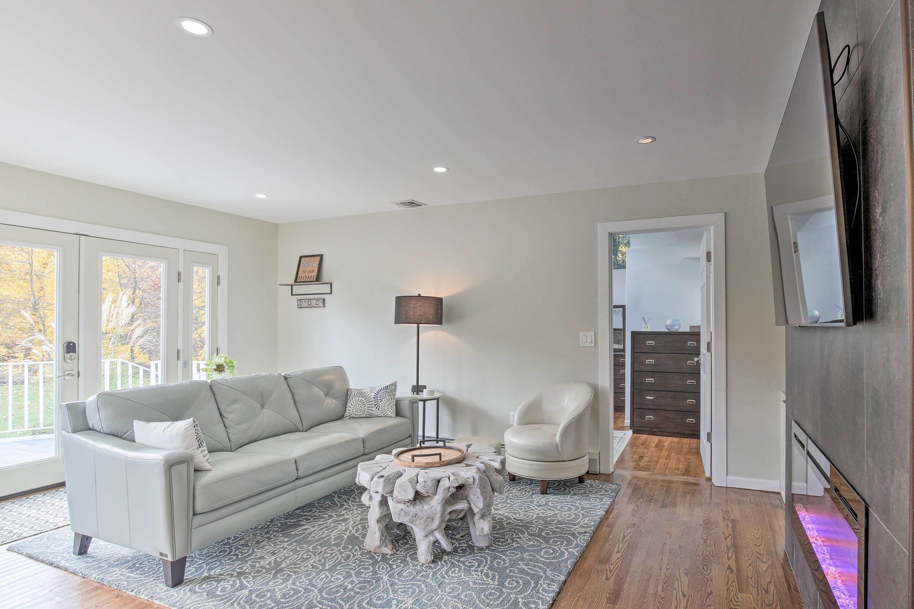 A modern living room with a grey sofa, a white armchair, a small round coffee table, and a floor lamp.