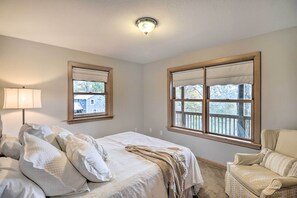 A bedroom with a bed, a chair, a window, and a lamp. - Luxe Franklin Home Features Indoor/outdoor Comfort (Franklin)