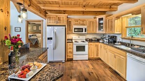 A kitchen with wooden cabinets, a refrigerator, a microwave, and a stove. - Luxe Franklin Home Features Indoor/outdoor Comfort (Franklin)