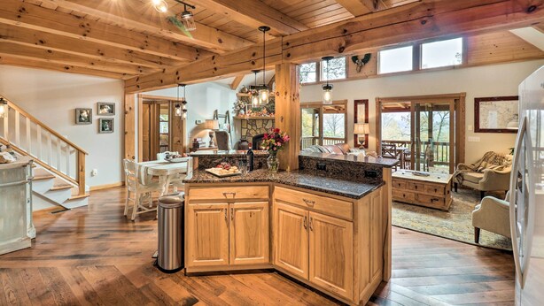 A spacious kitchen with wooden beams, a large island, and a dining area with a view to the outdoors. - Luxe Franklin Home Features Indoor/outdoor Comfort (Franklin)