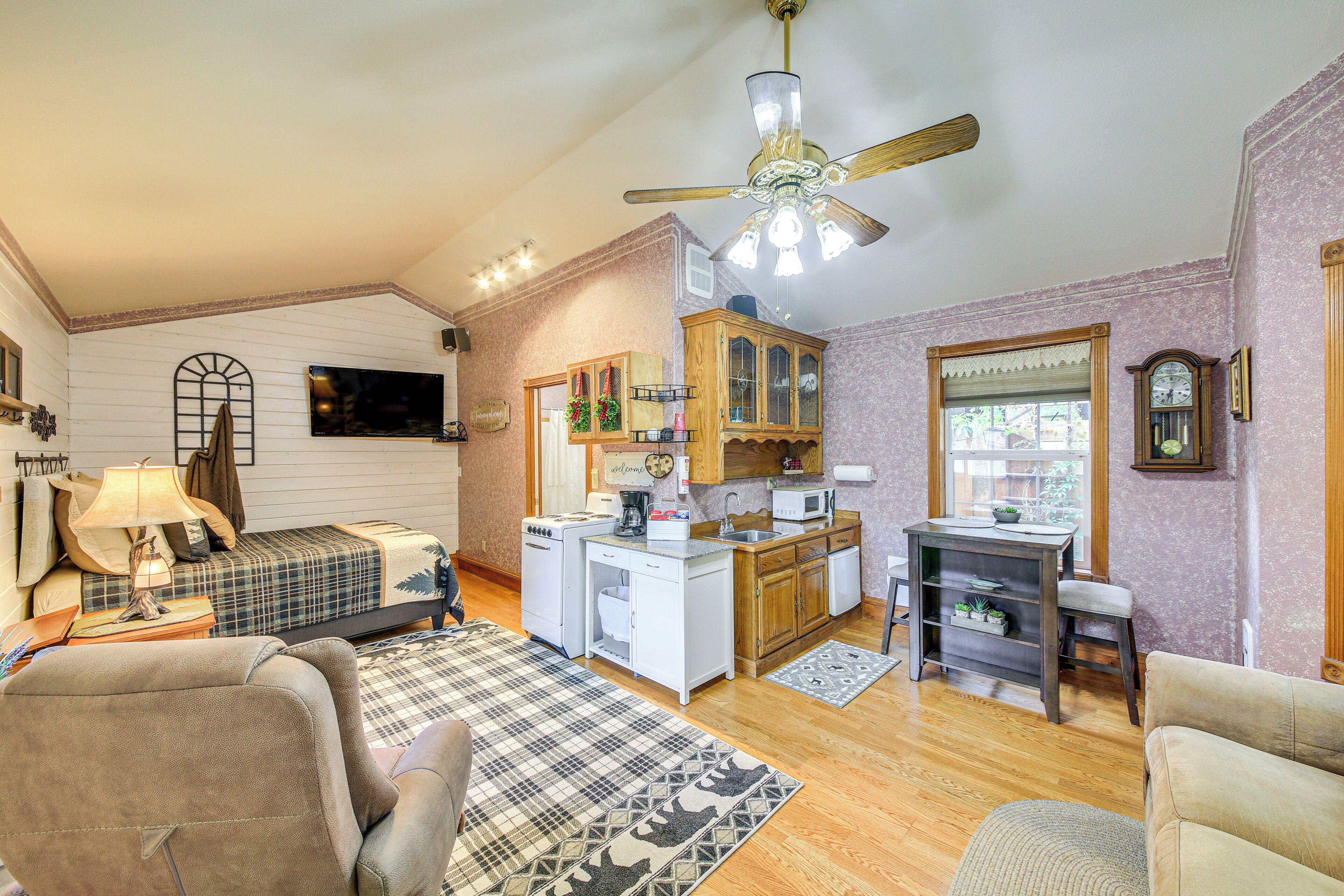 A compact living space with a kitchenette, a dining area, and a bedroom.
