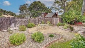 A backyard with a wooden deck, a dining table with chairs, and a small shed. - 2 Mi to Dtwn Atascadero! Cozy Cottage w/ Yard (Atascadero)