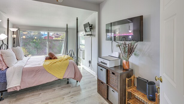 A bedroom with a bed, bedside table, and a large window. - 2 Mi to Dtwn Atascadero! Cozy Cottage w/ Yard (Atascadero)