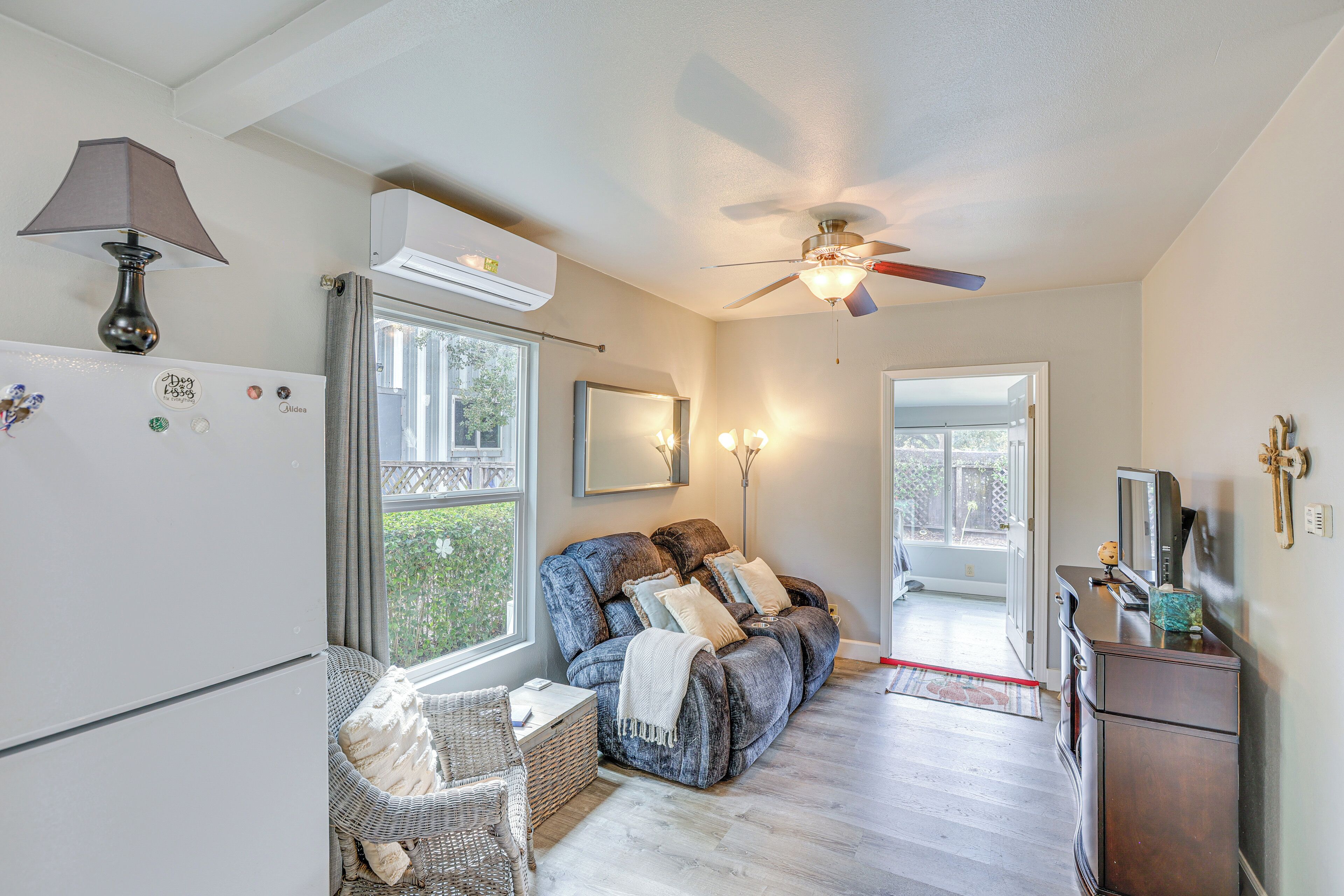 Un salon confortable avec un canapé, un téléviseur et un ventilateur de plafond.